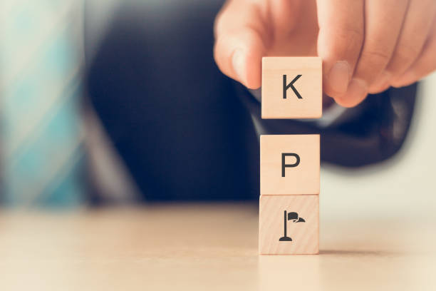 istock Banner KPI concept. Key Performance Indicator using business intelligence metrics to measure achievement versus planned target.  Businessman hold wooden cubes with 