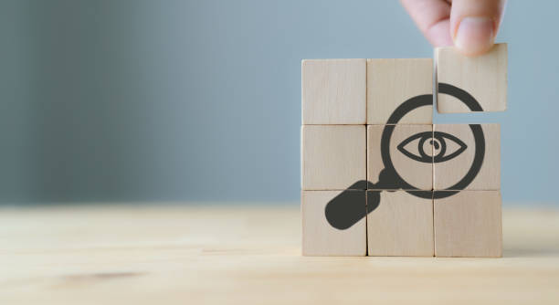 istock Search, Research, Finding Solution, Investigate Concept. Hand holds the wooden cubes with magnifying glass with eye symbols on grey background, copy space. Marketing research. Customer insight. 1371651715