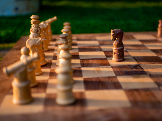 istock Wooden chess board with wooden pieces with sunlight. 1371654706