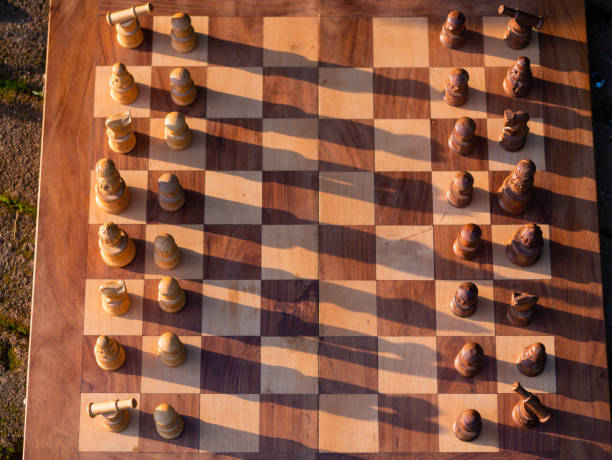 istock Wooden chess board with wooden pieces with sunlight 1371654800