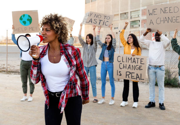 気候変動に抗議するメガホンを通じて叫ぶアフリカ系アメリカ人女性 - 環境保護主義者 ストックフォトと画像