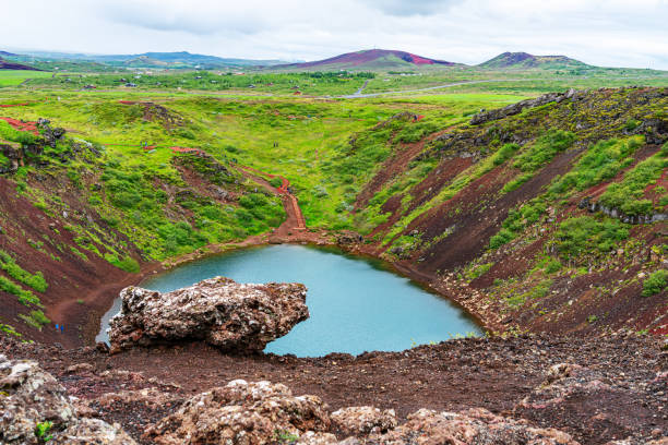 vista do vulcão kerid e lago de crateras vulcânicas kerid com campo verde e rochas de lava vulcânica. - kerith - fotografias e filmes do acervo