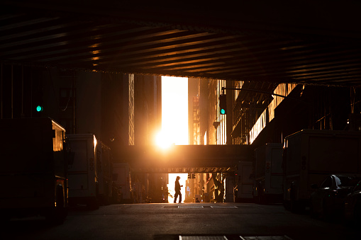 Person crossing the street at sunset in midtown Manhattan.