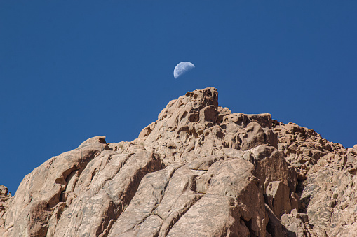 Third Quarter Moon during daylight behind rock formations in Mount Sinai, Egypt