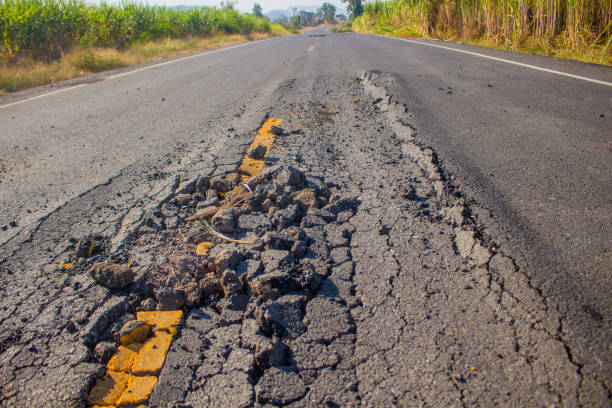 beschädigte straßen in ländlichen gebieten. beschädigter asphalt. es ist gefährlich, auf dieser straße zu fahren. - regenstein stock-fotos und bilder