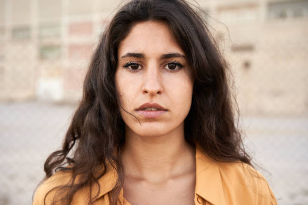 giovane donna sicura di sé con gli occhi scuri che guarda la telecamera con un'espressione seria sul viso. - teenager adolescence portrait pensive foto e immagini stock