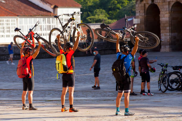 ciclistas, peregrinos na praça obradoiro, santiago de compostela, chegando do caminho de santiago. - group of people journey effort travel destinations - fotografias e filmes do acervo