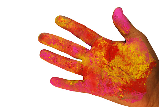 Colourful mix of holi powder colors in bright vibrant yellow and magenta pink isolated over white backgrounds all over a human hand or palm. Ideal for posters, greeting cards, postcards related to the Indian Hindu festival of colors - Holi. There is no text and ample copy space.