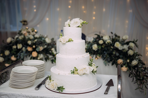 A four-tiered cake decorated with green leaves.