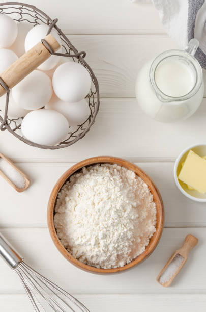 istock Ingredients for making traditional thin pancakes or crepes on a white wooden background. Recipe step by step. Food for Maslenitsa. 1371687708