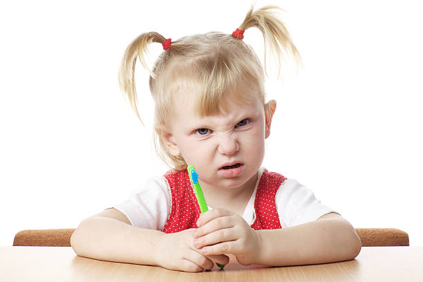 displeased child with toothbrush stock photo