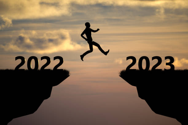 istock Silhouette man jumping on a cliff from 2022 to 2023 with sunset sky background 1371690001