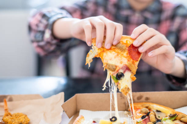 istock Child's hand holding pizza 1371690014