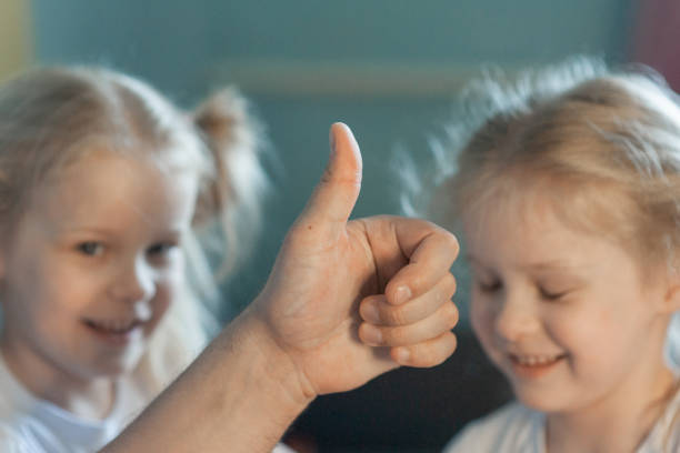 istock dad shows class with thumb on the background of children 1371694229
