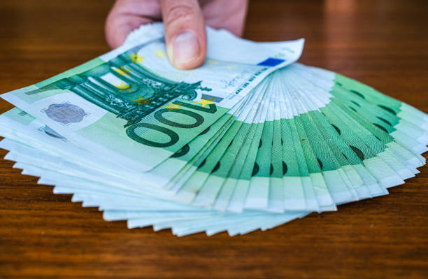 Handing over money. 100 Euro bills. stock photo