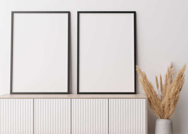 istock Two empty vertical picture frames standing on wooden sideboard. Mock up interior in contemporary style. Free space for picture, poster. Console, vase with pampas grass. 3D rendering. 1371696882