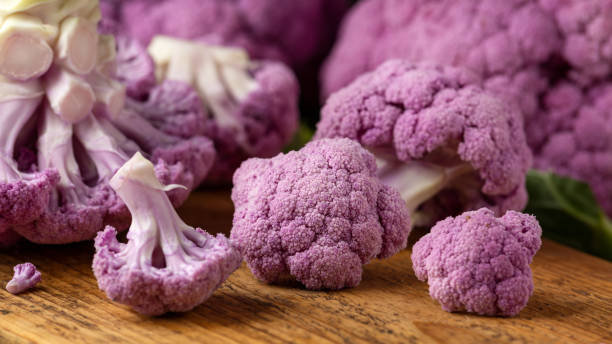istock Purple colourful cauliflower on wooden rustic board. 1371697148