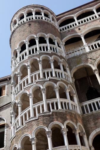 The historic, old building and external spiral staircase which leads to a bell tower.  Known as Palazzo Contarini del Bovolo, located in the San Marco area of Venice, Italy.   