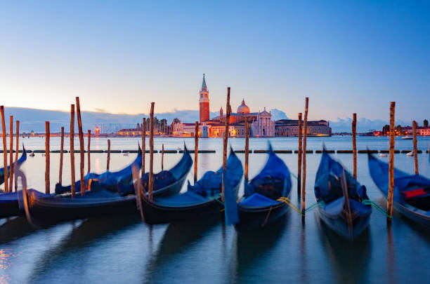 Moored Gondolas and San Giorgio Maggiore at Sunrise in Venice Italy. Movement in the Boats due to Long Exposure grand canal venice stock pictures, royalty-free photos & images