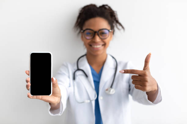 istock Doctor pointing at big white empty smartphone screen, mock-up 1371699794