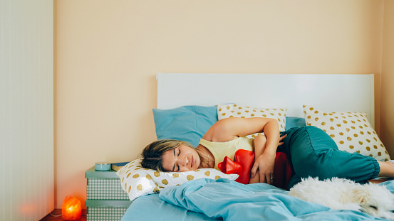 Mujer con dolor de estómago quedándose en casa photo