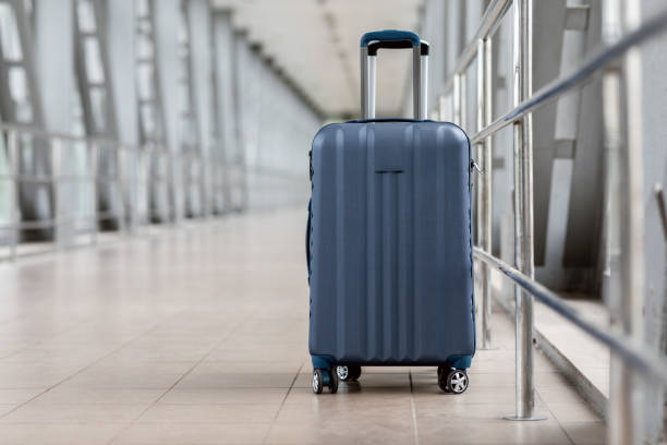 Closeup Shot Of Stylish Cabin Baggage Suitcase Standing In Empty Airport Hall Closeup Shot Of Stylish Cabin Baggage Suitcase Standing In Empty Airport Hall, Blue Hand Luggage Bag Waiting At Terminal, Advertisement Banner For Air Travels And Flight Bookings, Copy Space hand luggage stock pictures, royalty-free photos & images