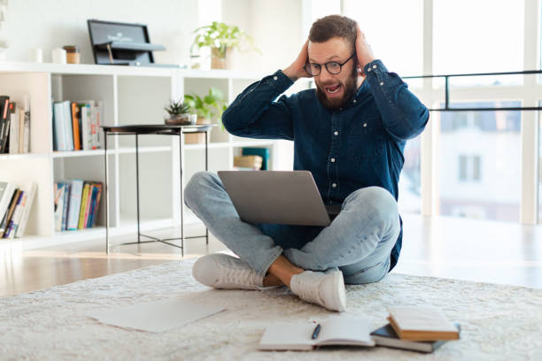istock Shocked Man Looking At Laptop Shouting Sitting On Floor Indoor 1371701509