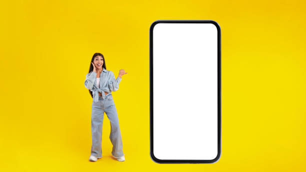 istock Woman showing white empty smartphone screen and pointing at panel 1371701548