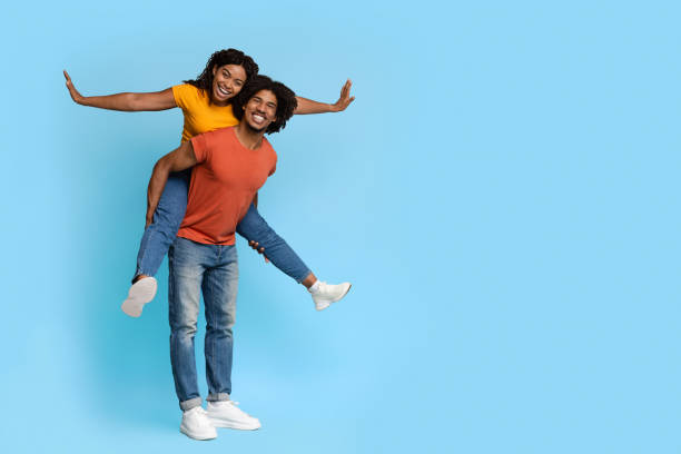 istock Cheerful black lady piggybacking her handsome boyfriend 1371701683