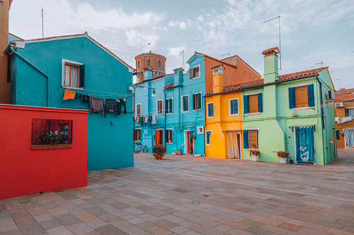 Colourful houses on the canal in famous travel destination Burano island and boats lining side canals with beautiful reflection in Burano, Venice, Italia