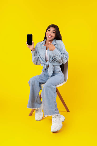 istock Woman showing white empty smartphone screen and pointing 1371702821