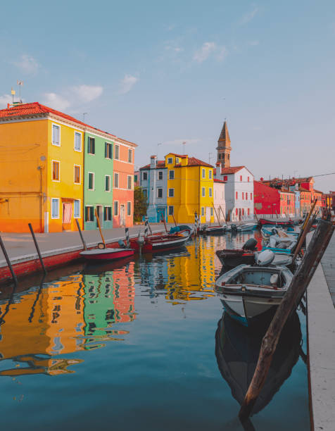 Colorful houses on the canal in Burano Town, Venice, Italy Colourful houses on the canal in famous travel destination Burano island and boats lining side canals with beautiful reflection in Burano, Venice, Italia murano stock pictures, royalty-free photos & images