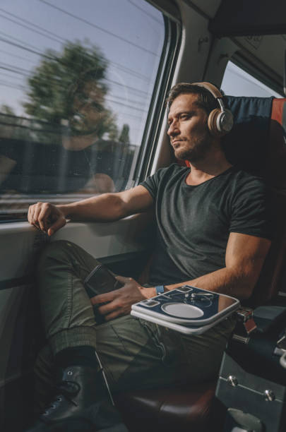 istock Young Man Traveling In Train - Lost in thought 1371703159