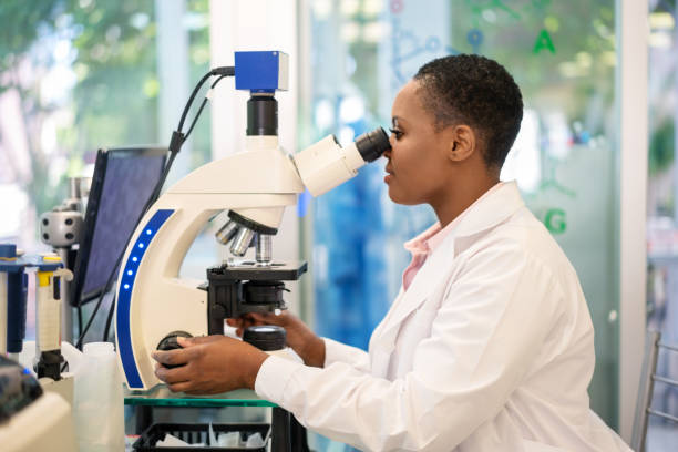 istock Woman scientist looking through a microscope in a laboratory 1371703258