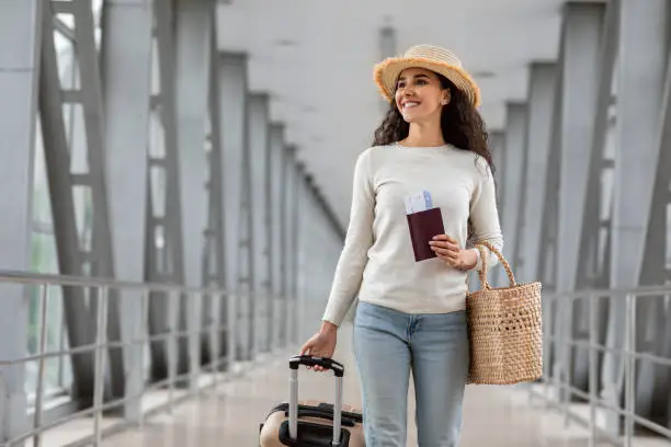 Photo of Vacation Travel. Beautiful Young Brunette Lady Wearing Wicker Hat Walking In Airport