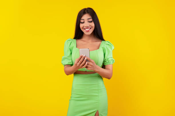 istock Happy young woman using mobile phone at studio 1371703707