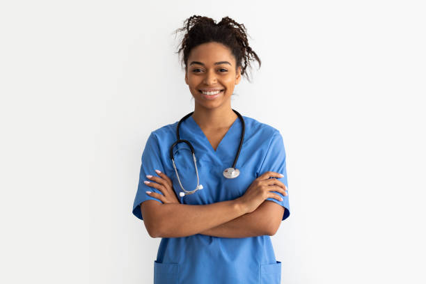 retrato de médico negro mirando a la cámara con los brazos cruzados - medical assistant fotografías e imágenes de stock