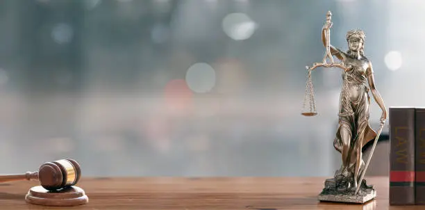 Photo of Legal and law concept. Statue of Lady Justice with scales of justice and wooden judge gavel on wooden table. Panoramic image statue of lady justice.