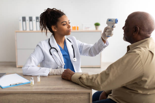 istock Doctor checking temperature of old man using infrared thermometer 1371704918