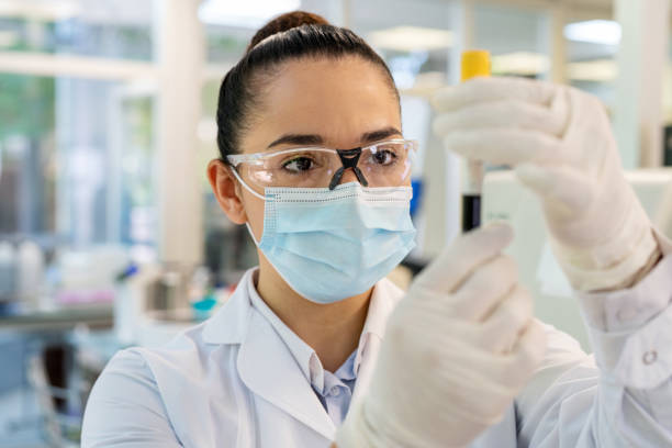 close-up de uma mulher cientista analisando uma amostra em tubo de ensaio em laboratório - blood sample blood tube pathologist - fotografias e filmes do acervo