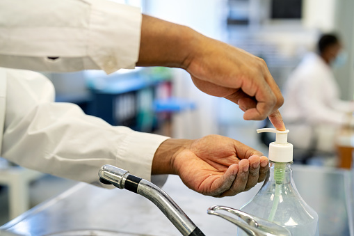 Cropped shot of a medical researcher disinfecting himself with hand sanitizer in the lab. Close-up of an unrecognizable male scientist sanitizing his hands regularly while working in the laboratory