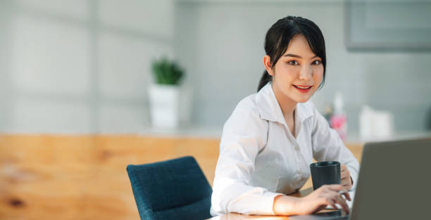 istock Confident asian businesswoman using laptop at work. Smiling and looking at camera. 1371706800