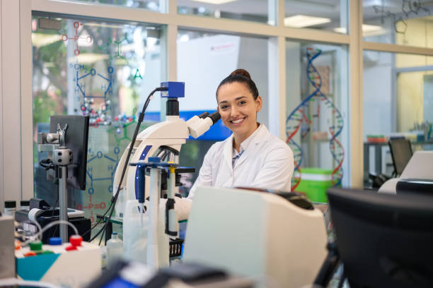 istock Portrait of young scientist sitting with microscope in laboratory 1371708039