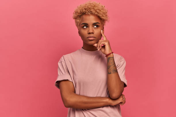 istock Dark skinned woman looks up with a pensive expression and plans something. 1371708118