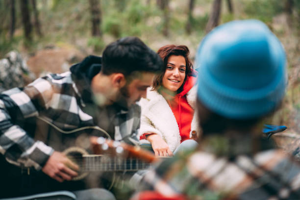 Friends Playing Guitar by the Campfire