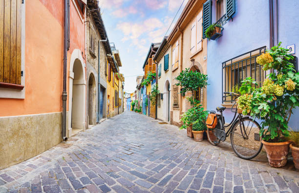 strada stretta del villaggio di pescatori san giuliano con case colorate e una bicicletta al mattino presto a rimini, italia - rimini foto e immagini stock