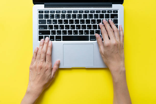 istock woman working on laptop while sitting in creative office or cafe on yellow table background 1371711017