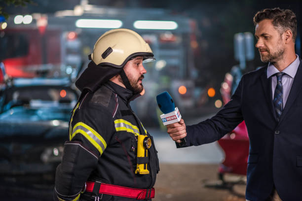 reportero entrevistando a un bombero masculino - action fire department car men fotografías e imágenes de stock