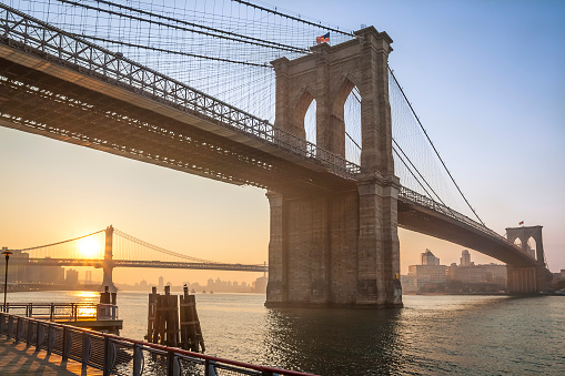 View of the iconic architecture of New York city in the USA by the famous Brooklyn Bridge at sunerise.