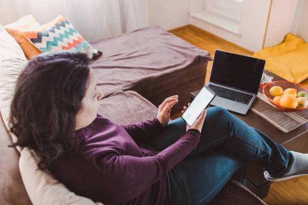 istock A brunette woman using phone at home 1371720444